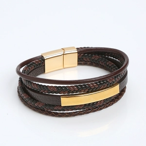 Detailed close-up of brown and black leather braided bracelet with gold magnetic clasp