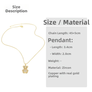 Detailed view of a gold bear necklace with white zircons and green gemstone eyes