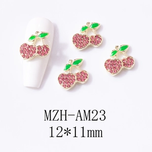 Detail view of 12x11mm golden cherry nail charms with pink crystals and green enamel leaf