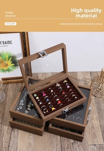 Close-up of walnut wood jewelry box with glass lid showing ring slots and metal clasp