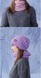 Detail of purple knitted beanie and neck warmer set with leather patch on snowy background