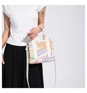 Dettaglio della borsa tote in velluto a coste crema con linee astratte colorate