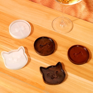 Detail of cat and bone pattern silicone molds with resin coasters on wooden table
