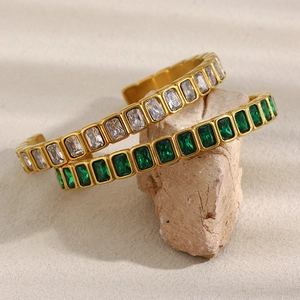 Detail von 18K vergoldeten Armbändern mit smaragdgrünen und weißen Zirkoniasteinen