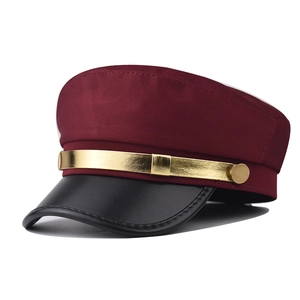 Détail d'une casquette gavroche bordeaux avec visière en similicuir noir et bande dorée