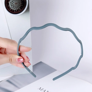 Detail view of wave-shaped grey-blue headband with non-slip teeth for secure grip