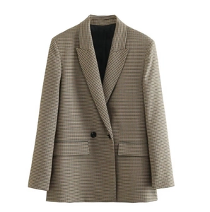 Detailed close-up of brown houndstooth blazer showing flap pockets and single button