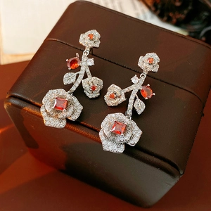Macro shot of vintage flower earrings with sparkling clear crystals and red gemstones
