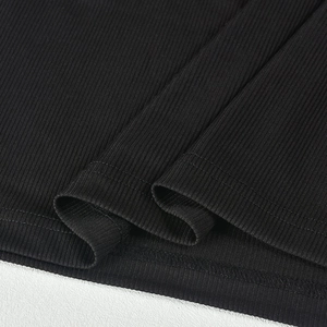 Detail of black knit dress hem showing ribbed texture and precise stitching lines