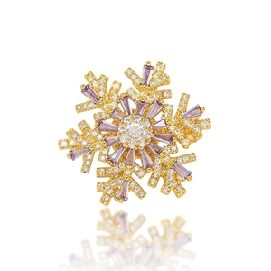 Macro detail of snowflake brooch with lavender rectangular zircon and 18K gold plating