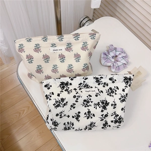 Detail of floral cotton makeup bags with simple wish labels and metal zipper closure