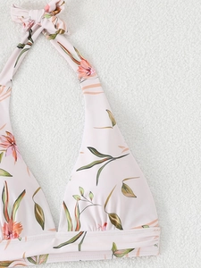 Detail of halter neck bikini top with tropical pink floral print on ivory fabric