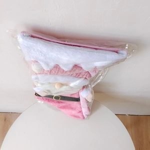 Pink and white knit Christmas stockings and plush outfits packed in transparent plastic bags