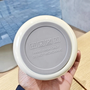 Close-up of bottom showing Hand Wash Only and Do Not Microwave icons on the tumbler