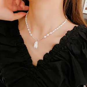 Elegant baroque pearl drop necklace with irregular pendant shown on a model neck