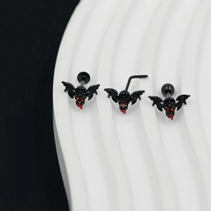 Macro detail of black bat body jewelry set with red rhinestones and three post types