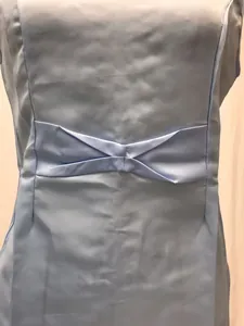 Détail d'une robe en satin bleu clair avec un nœud au dos et une texture soyeuse