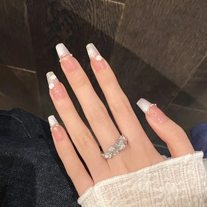Pink tulip press-on nails with pearl cat-eye design and floral cluster rings on hand