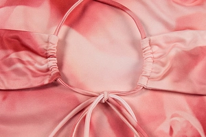 Detail of pink tie-dye dress featuring a ruched cutout design and delicate drawstring tie