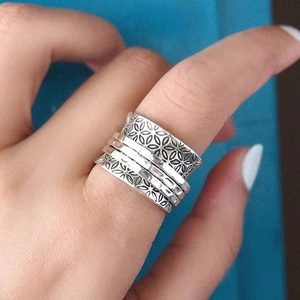 Macro detail of vintage silver spinner ring featuring intricate hollow floral textures
