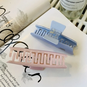 Detailed view of pink and light blue acetate hair claws with a glittery pearlescent finish
