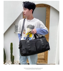 Detail view of large capacity black travel bag with waterproof nylon texture on a model