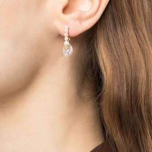 Elegant gold hoop earrings with detachable drop pearls shown on model in close-up shot
