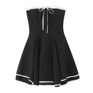 Close-up of black tube dress featuring white contrast piping and bow tie detail