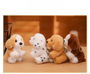 Detail view of four plush dog keychains with metal rings on a wooden surface