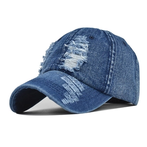 Distressed blue denim baseball cap with heavy ripped details and washed vintage style