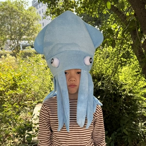 Close-up of a blue plush octopus hat with soft texture and cartoon eyes worn by a child