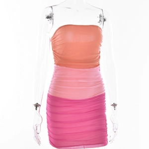 Détail du tissu en maille dégradé orange et rose avec texture froncée sur la robe moulante