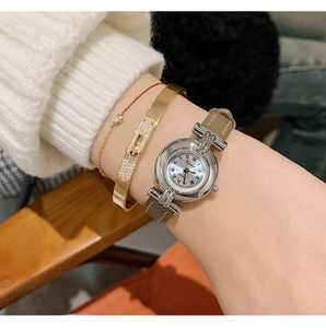 Close-up of DINIMI women's quartz watch with round silver case and grey leather strap