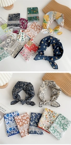 Detailed view of folded floral cotton linen square scarves with fashion paper labels