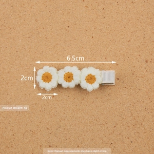 Detailed size view of three white crochet daisy flowers on a metal hair clip, 6.5cm length