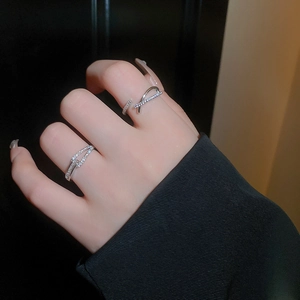 Gros plan d'une bague croisée en zircon étincelant sur main avec fond noir profond
