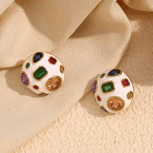 Macro detail of 18K gold-plated dome earrings with white enamel and colorful zirconia