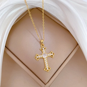 Detailed close-up of a gold cross pendant necklace featuring brilliant sparkling crystals