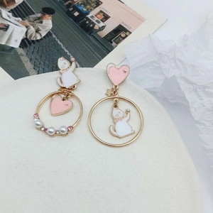 Detail of asymmetric cat and pink heart earrings with pearls and crystals on gold finish