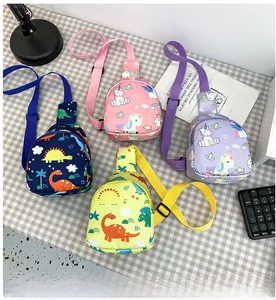 Detailed flat lay of children's dinosaur and unicorn print sling bags in multiple colors