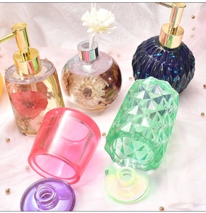 Détail de distributeurs de savon en résine colorée avec motifs à facettes dorées