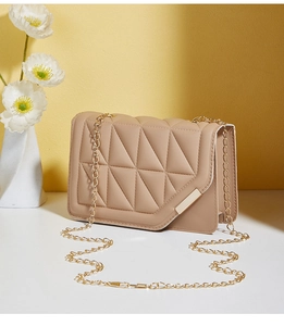 Detail of khaki geometric quilted bag with gold chain strap and metallic closure