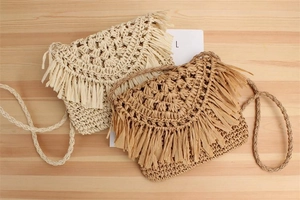 Detail of handmade straw crossbody bags with bohemian fringe and woven strap texture