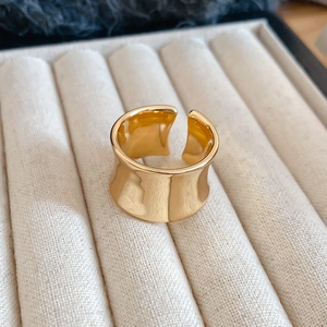 Detailed close-up of a minimalist gold concave wide open ring on a velvet jewelry tray