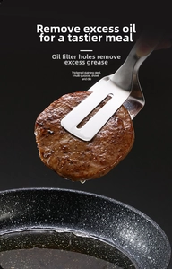 Detail of slotted stainless steel food tongs draining oil from grilled meat on black background