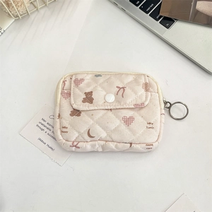 Detailed macro view of quilted floral card holder with metal zipper ring and snap button