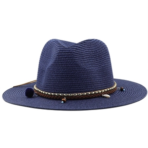 Détail d'un chapeau de paille bleu foncé avec glands, perles et décorations en coquillages