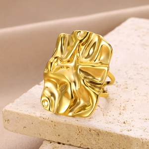 Macro view of a gold textured geometric statement ring on a natural stone base