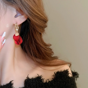 Detail view of red frosted petal tassel earrings with gold accents and sparkling crystals