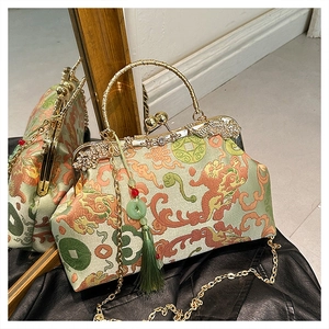 Detailed macro view of green brocade embroidery with dragon motif and gold tassels